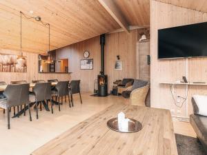 a living room with a table and chairs and a tv at Luxury Retreat by Kramnitze in Rødby
