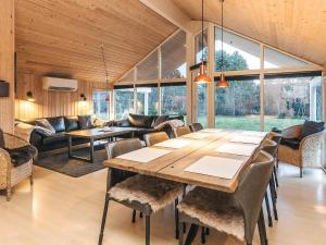 a living room with a large wooden table and chairs at Luxury Retreat by Kramnitze in Rødby