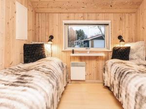 two beds in a room with a window at Luxury Retreat by Kramnitze in Rødby
