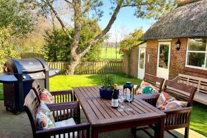 a picnic table with two chairs and a grill at Villa Verano in Noordwijk aan Zee