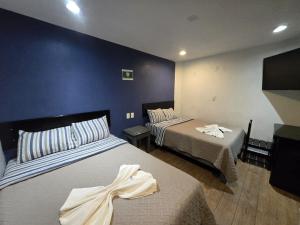 a hotel room with two beds with towels on them at Hotel Santo Domingo in Comitán