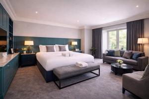 a bedroom with a bed and a living room with a couch at The Regency Hotel in Solihull +48 photos