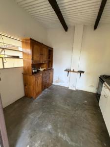 an empty kitchen with wooden cabinets in a room at Habitación con baño privado con cocina separada in Villa Cura Brochero