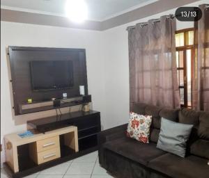 a living room with a couch and a flat screen tv at Chácara Vicente Gazzi in Socorro