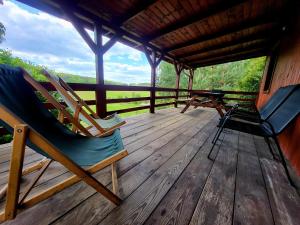two chairs and a table on a wooden deck at Domek Jabłoniowy in Małe Leżno