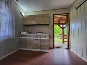 a kitchen with wooden cabinets and a sliding glass door at Domek Jabłoniowy in Małe Leżno
