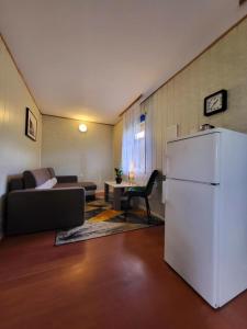 a living room with a refrigerator and a couch at Domek Jabłoniowy in Małe Leżno
