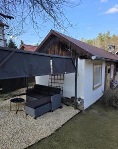 a black couch under awning next to a house at Domek pod Lawendą, Roztocze in Rebizanty