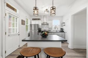 a kitchen with a island with two stools at Bright & Clean 2BR Near Downtown Porch Parking in Pittsburgh