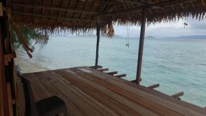 a porch of a hut on the beach with the water at Villa Homestay in Mesemta +23 photos