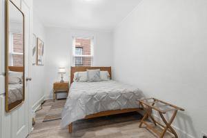 a white bedroom with a bed and a mirror at Bright & Clean 2BR Near Downtown Porch Parking in Pittsburgh