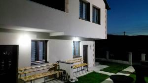 a white house with a porch with benches and windows at Household Grbovic in Bijelo Polje