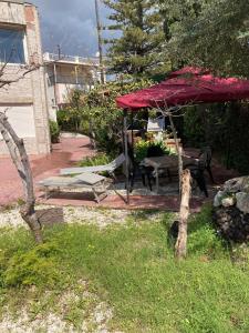 a backyard with a picnic table and a red tent at Villa Marine Plus in Fontane Bianche
