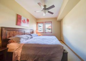 a bedroom with a bed with a ceiling fan at Top Floor Beautiful Mountain Views! 2 Bed 2 Bath in Canmore