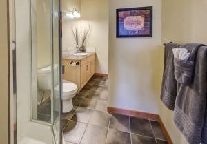 a bathroom with a toilet and a glass shower at Top Floor Beautiful Mountain Views! 2 Bed 2 Bath in Canmore