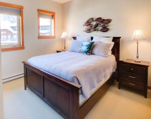a bedroom with a large bed and two lamps at Top Floor Beautiful Mountain Views! 2 Bed 2 Bath in Canmore +17 photos