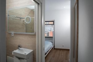 a small bathroom with a sink and a bed at Guest House Vasco da Gama in Lagos