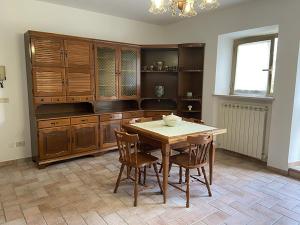 a kitchen with wooden cabinets and a table and chairs at Casa Erica Todi in Todi