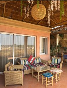 a screened in porch with a couch and a table at Maison Mamdy Triplex & Rooftop in Marrakesh