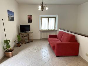 a living room with a red couch and a television at Casa Erica Todi in Todi