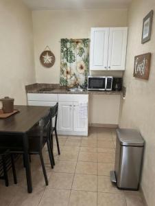 a kitchen with a table and chairs and a microwave at Beach Colony Motel in Wildwood Crest