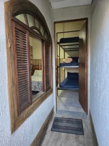 a room with a window and a room with bunk beds at Pousada Casa da arara Suite 106 in Saquarema