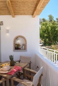 a patio with a table and chairs on a balcony at Le Reve in Aegiali