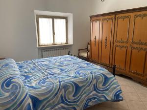 a bedroom with a bed with a blue and white blanket at Casa Erica Todi in Todi
