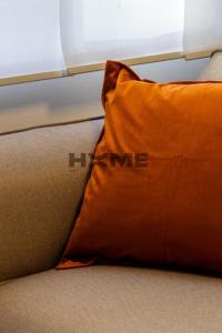 an orange pillow sitting on top of a bed at Vanderburch 70's in Cambrai