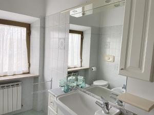 a white bathroom with a sink and a mirror at Casa Erica Todi in Todi +26 photos