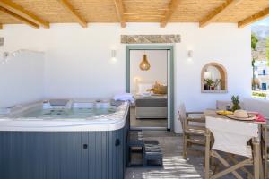 a jacuzzi tub in a room with a dining table at Le Reve in Aegiali +250 photos