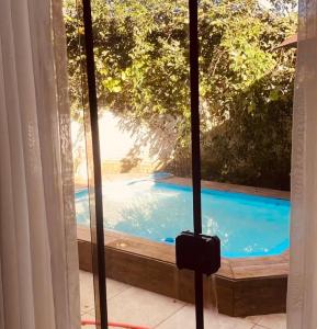 a view of a swimming pool through a window at Refúgio do Ipê Rosa in Tubarão