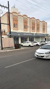 a street with cars parked in front of a building at Alturya in Al-ʿUla +2 photos