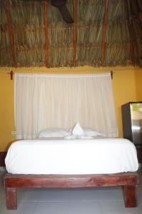 a bedroom with a bed with a white bedspread at Cabañas "El jardín del Edén" in Valladolid +9 photos
