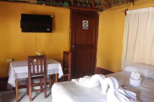 a room with two beds and a flat screen tv at Cabañas "El jardín del Edén" in Valladolid