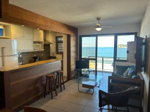 a kitchen with a view of the ocean from a room at Beach Front 2 Bed Rooms - Balcony with Full Sea View - Praia do Pepê in Rio de Janeiro