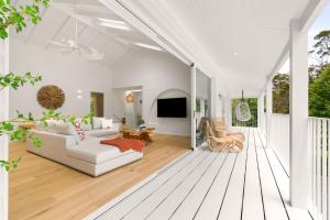 a living room with a white couch and a tv at Casa Scenic MacMasters Beach in Macmasters Beach