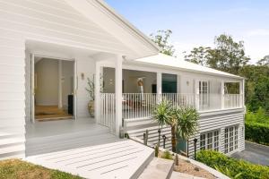 a white house with a front porch with a white deck at Casa Scenic MacMasters Beach in Macmasters Beach +49 photos