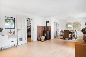 a living room with a fireplace and a dining room at 10253-Ulfborg-Sognegardsvej-13 in Ulfborg