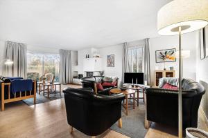 a living room with black leather chairs and a table at 10253-Ulfborg-Sognegardsvej-13 in Ulfborg