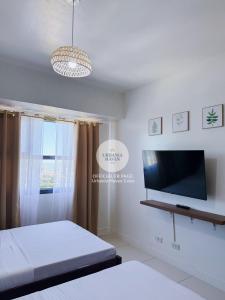 a bedroom with two beds and a flat screen tv at Urbania Haven Cebu2 in Cebu City +3 photos