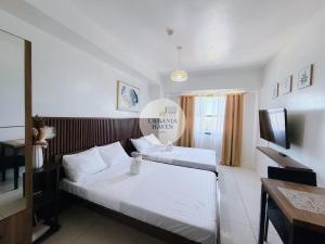 a hotel room with two beds and a television at Urbania Haven Cebu2 in Cebu City
