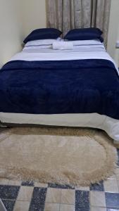 a bed with a blue comforter and a rug at Ebenezer Comfort in Bellevue Chopin