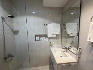 a bathroom with a sink and a shower with a mirror at متسع للشقق المخدومة - اقتصادي in Hail +18 photos