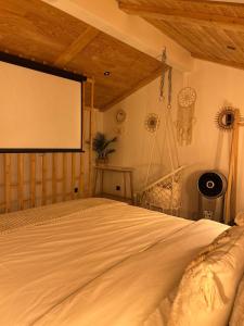 a bedroom with a bed and a projection screen at Le 39 bis in Jalhay
