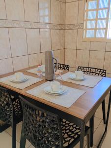 a table with two chairs and a coffee maker on it at Refúgio Aura,casa com suíte, wi-fi, garagem e churrasqueira in Aparecida