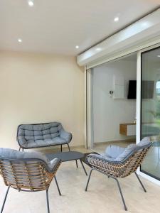 a living room with two chairs and a couch at Le Cocon du Cos in Ducos
