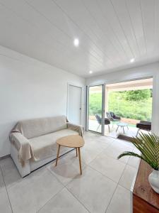 a living room with a couch and a table at Le Cocon du Cos in Ducos