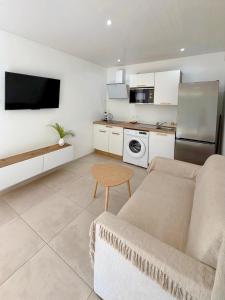 a living room with a couch and a kitchen at Le Cocon du Cos in Ducos +2 photos