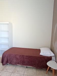 a small bedroom with a bed with a brown blanket at Refúgio Aura,casa com suíte, wi-fi, garagem e churrasqueira in Aparecida +33 photos